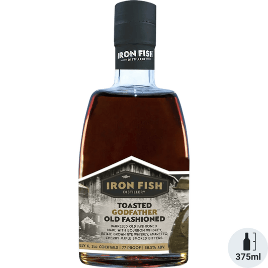 A bottle of Iron Fish Toasted Godfather Old Fashioned cocktail, displaying the liquid color and branding information on the label.