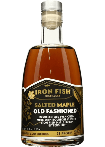 A bottle of Iron Fish Salted Maple Old Fashioned cocktail mix, with branding and text indicating the product is made with bourbon whiskey, maple syrup, bitters, and salt.