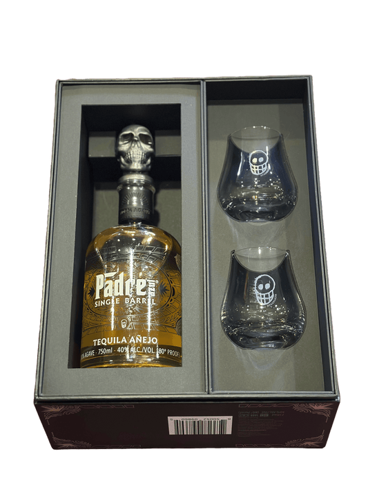 Padre Azul Año Tequila with two glasses, presented in a black bottle with a skull design, within a black box with a clear viewing window.