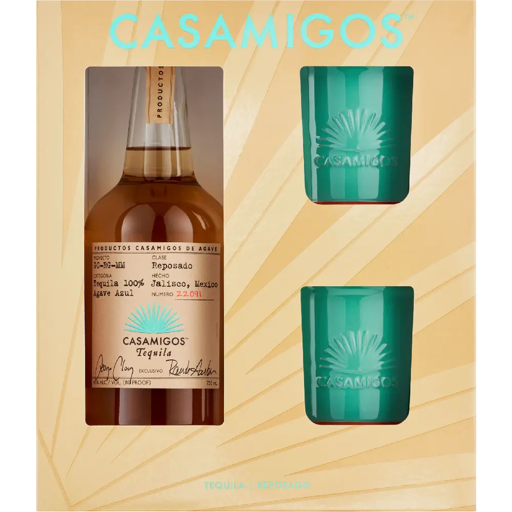 Casamigos tequila bottle and two green shot glasses on a beige background