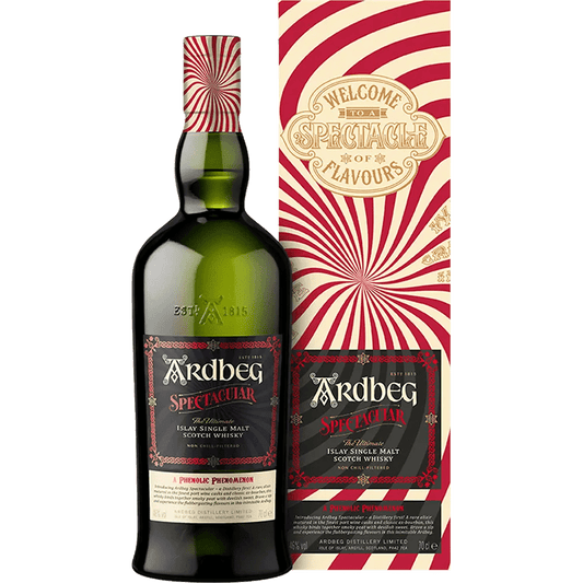 A bottle of Ardbeg Spectacular Single Malt Scotch with a colorful striped pattern on the label, next to its packaging box.